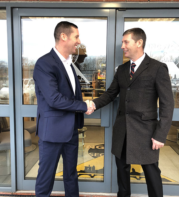 Alan Lingwood Snr & Jnr shaking hands outside the company head office